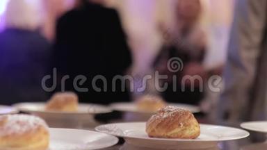 在与背景模糊的人举行的<strong>生日宴</strong>会上，手拿着小面包